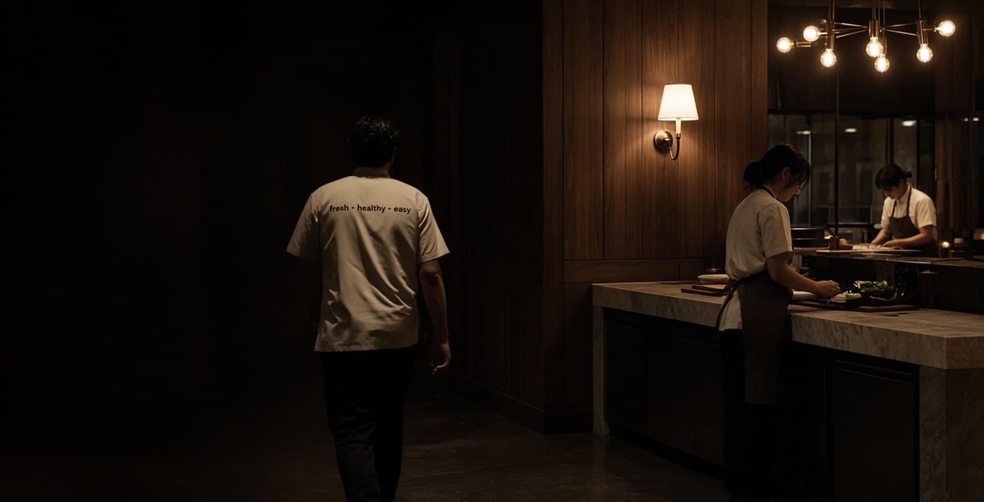 Hospitality staff in a dark dining room, type space on the left